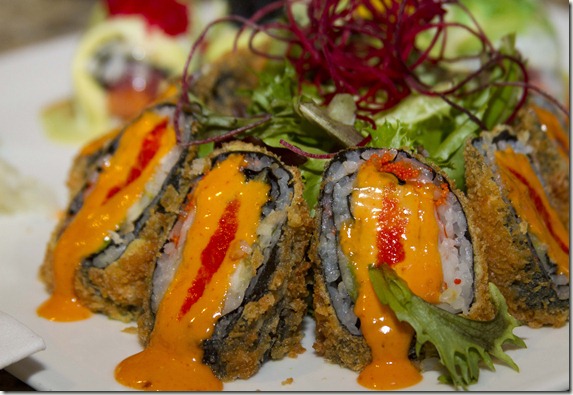 sushi with orange and red sauce in shape of a volcano