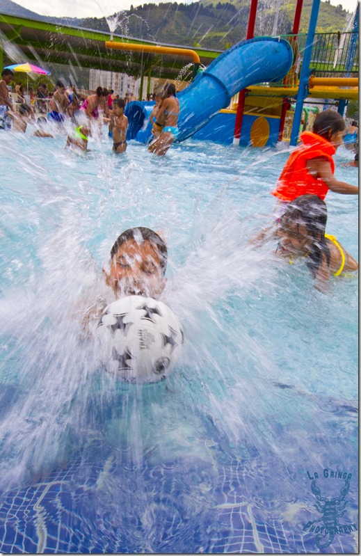 boy splashing in a pool to catch a soccer ball, kids playing at a water park, water park ,water, slides, medellin, colombia, south america, la gringa photos, going nomadic