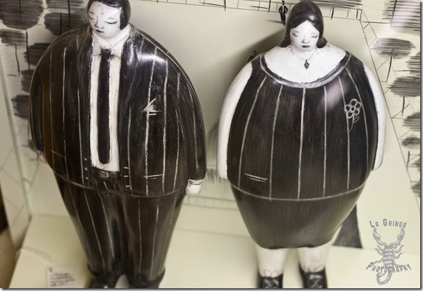 botero like man and woman statues, fat couple, black and white people carvings