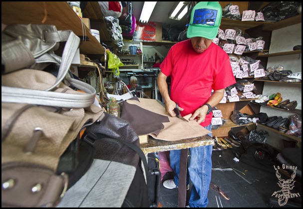 man cutting leather, man in purse factory, making bags, seamster