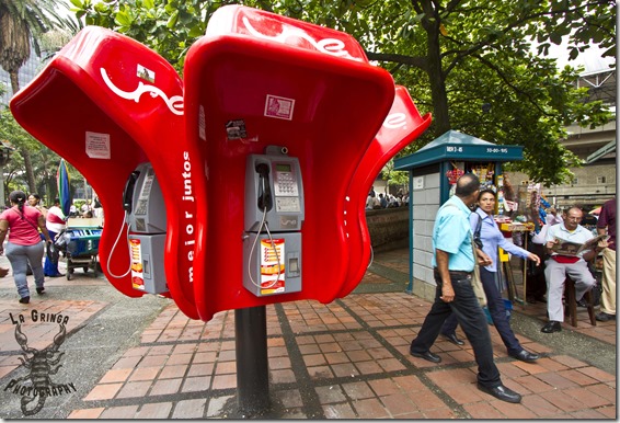 red payphone booths in brick park, street photos, medellin, colombia