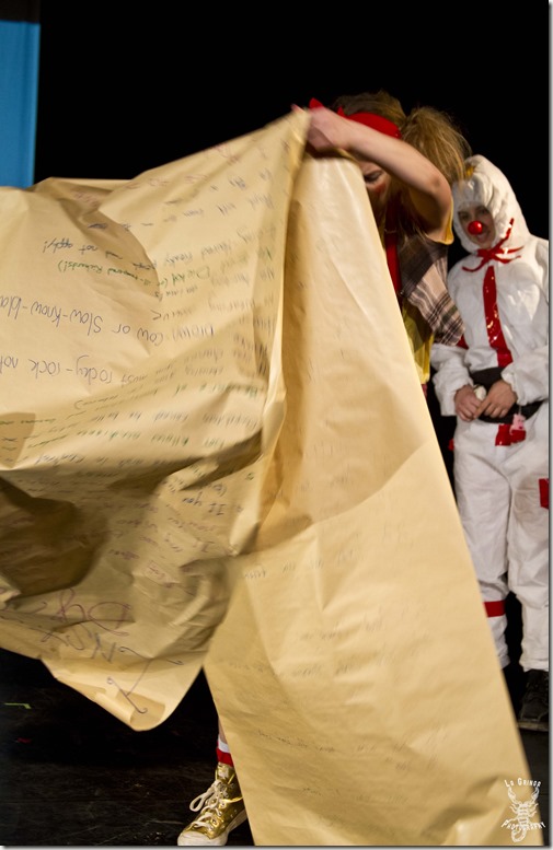 clown rules, big brown paper, list of rules, clown in CDC suit, biohazard suit, clown in biohazard suit, oversized rules, oversized list, huge paper, clown in paper, paper mess, toronto, canada, ontario, toronto festival of clowns, red nose district, clown, clowns, performance, stage, theater